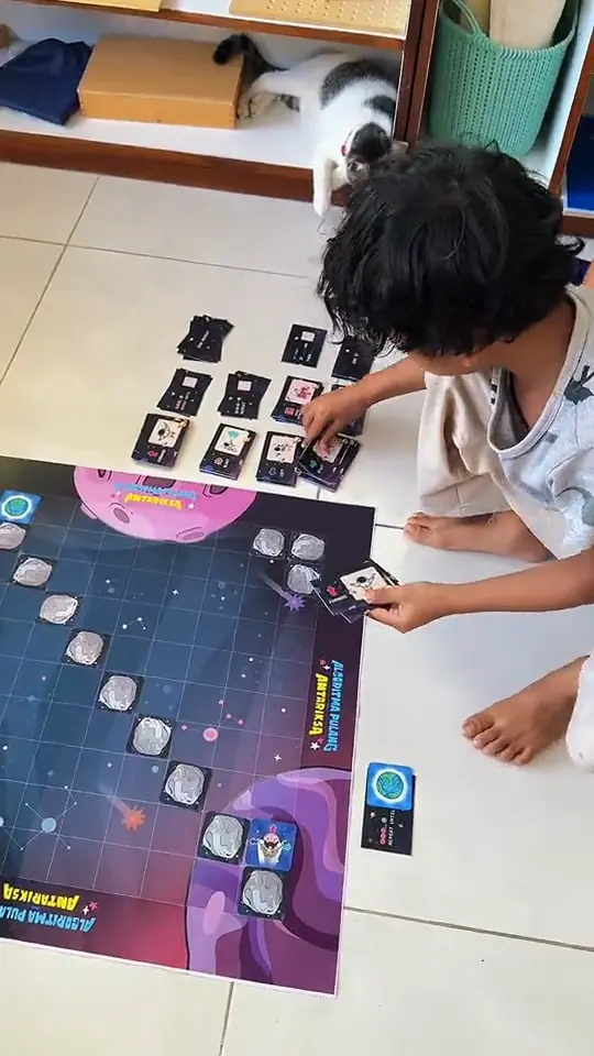 Anak bermain Algoritma Pulang Antariksa di lantai rumah.